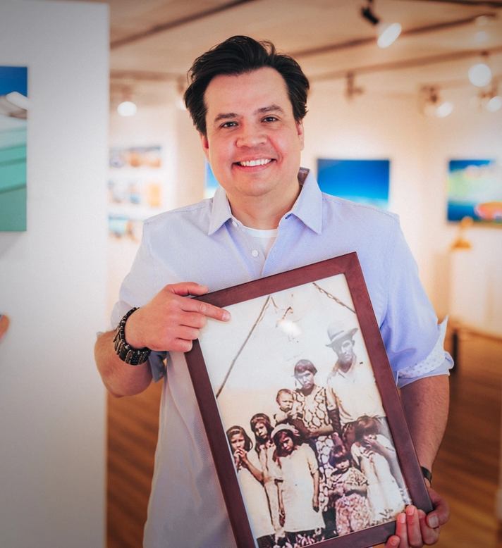 A man holding a framed picture.