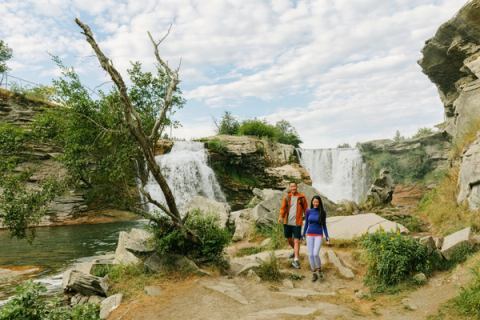 A couple walks along the rocks at Lundbreck Falls, located near the Crowsnest Pass.