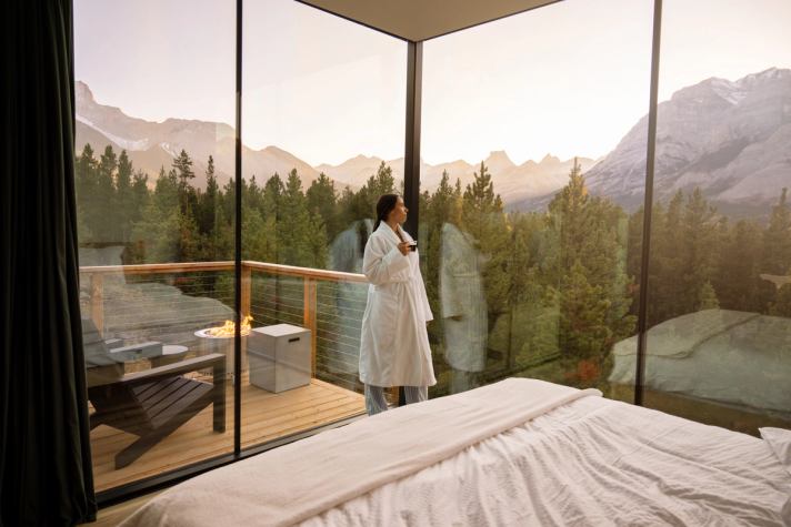 Person enjoys the sunset on the cabin balcony at Skyridge Glamping