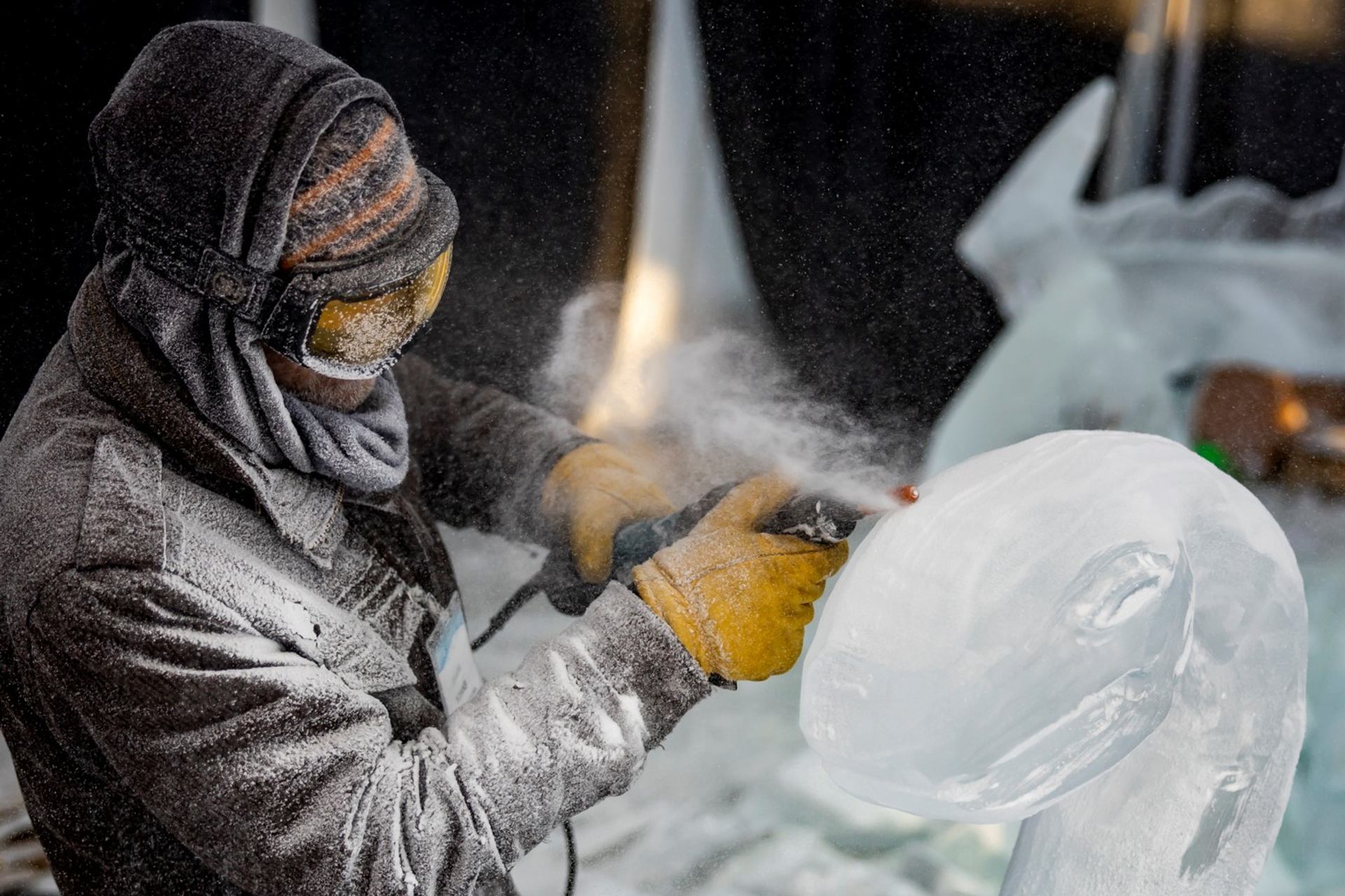 An ice carver works on a large ice sculpture.