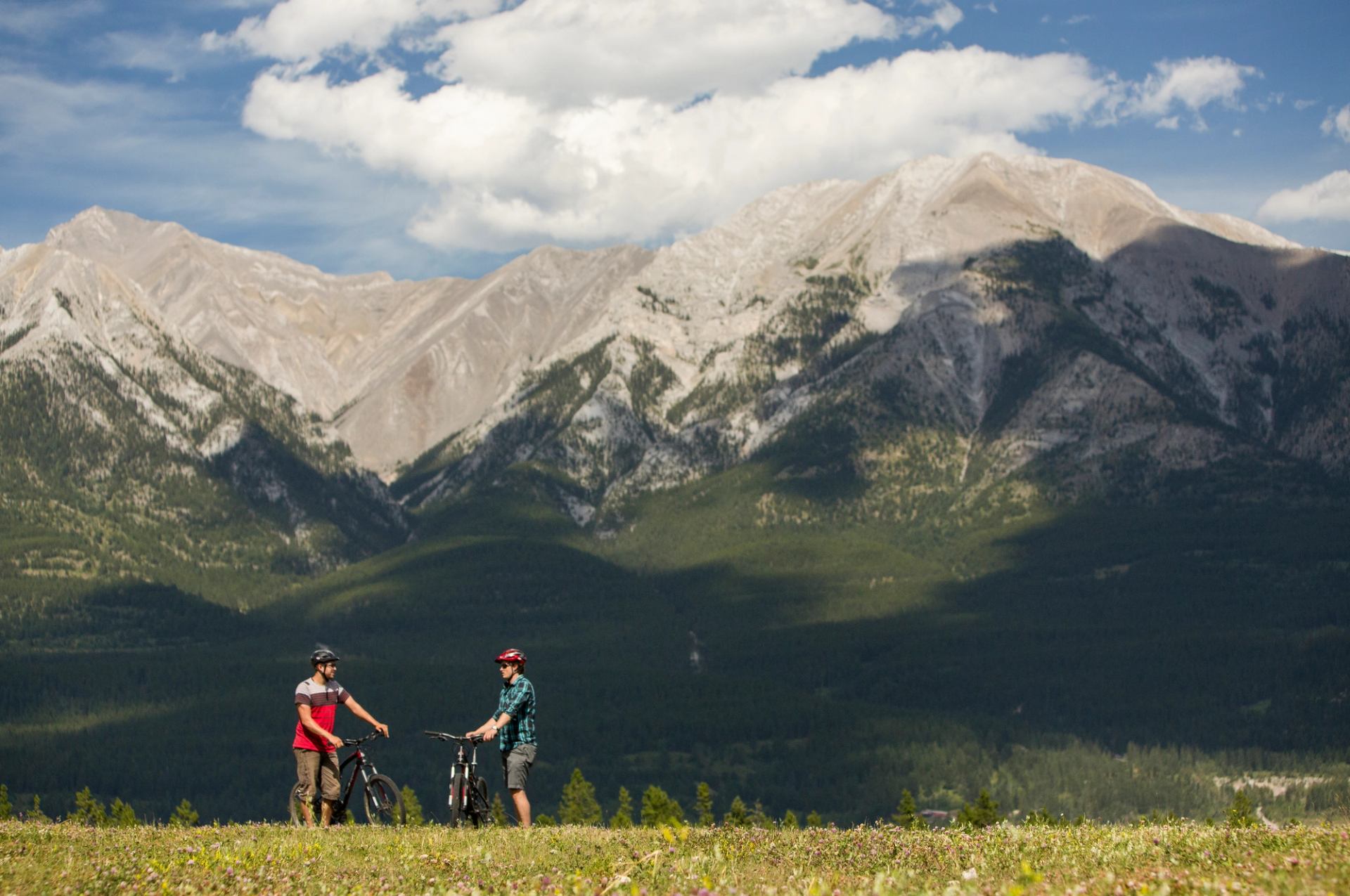 People take a break from mountain biking at the Nordic Centre in Canmore, surrounded by the Canadian Rockies.