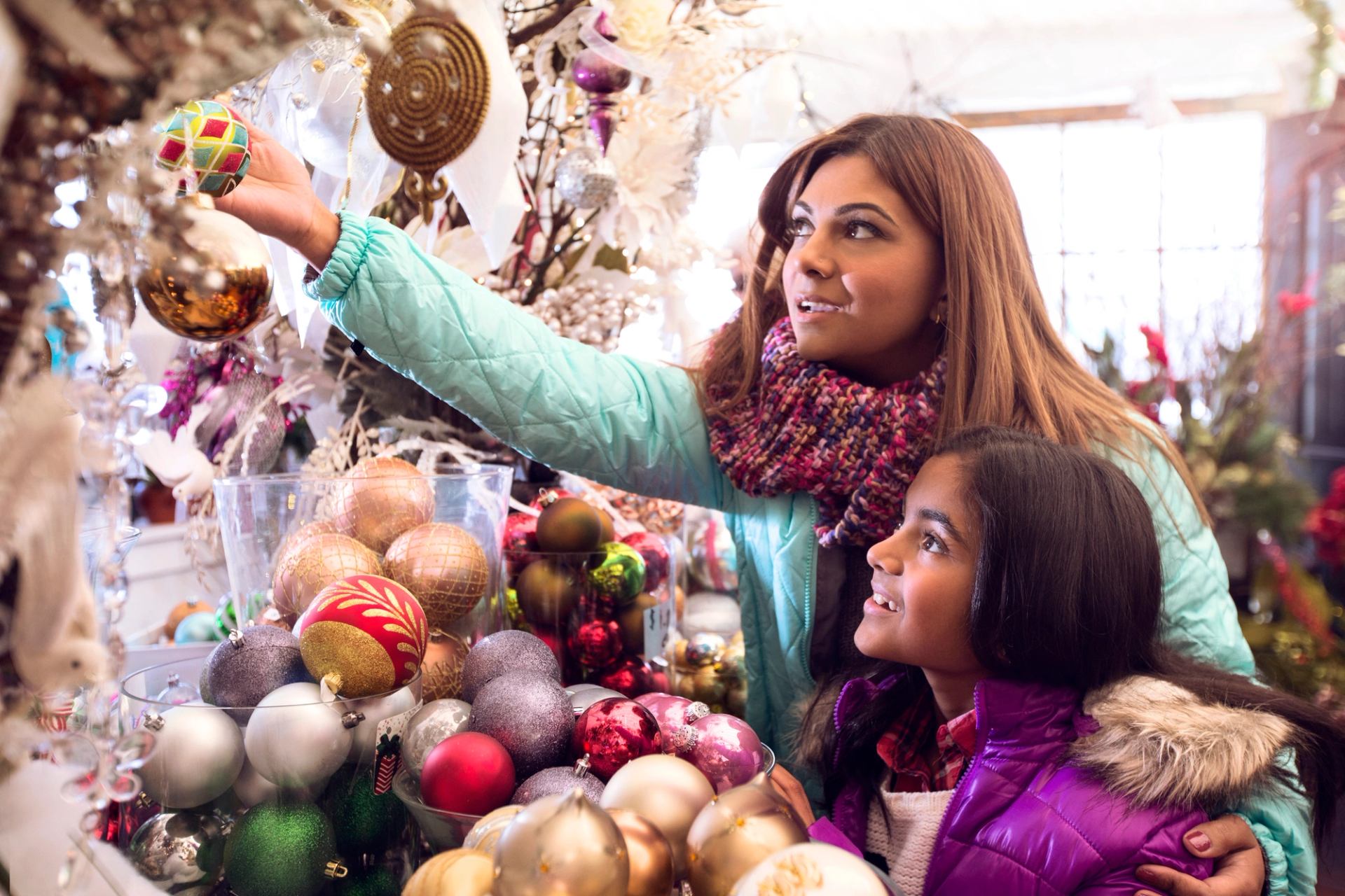 A mother and child looking at Christmas ornaments while shopping at the Spruce Meadows International Christmas Market