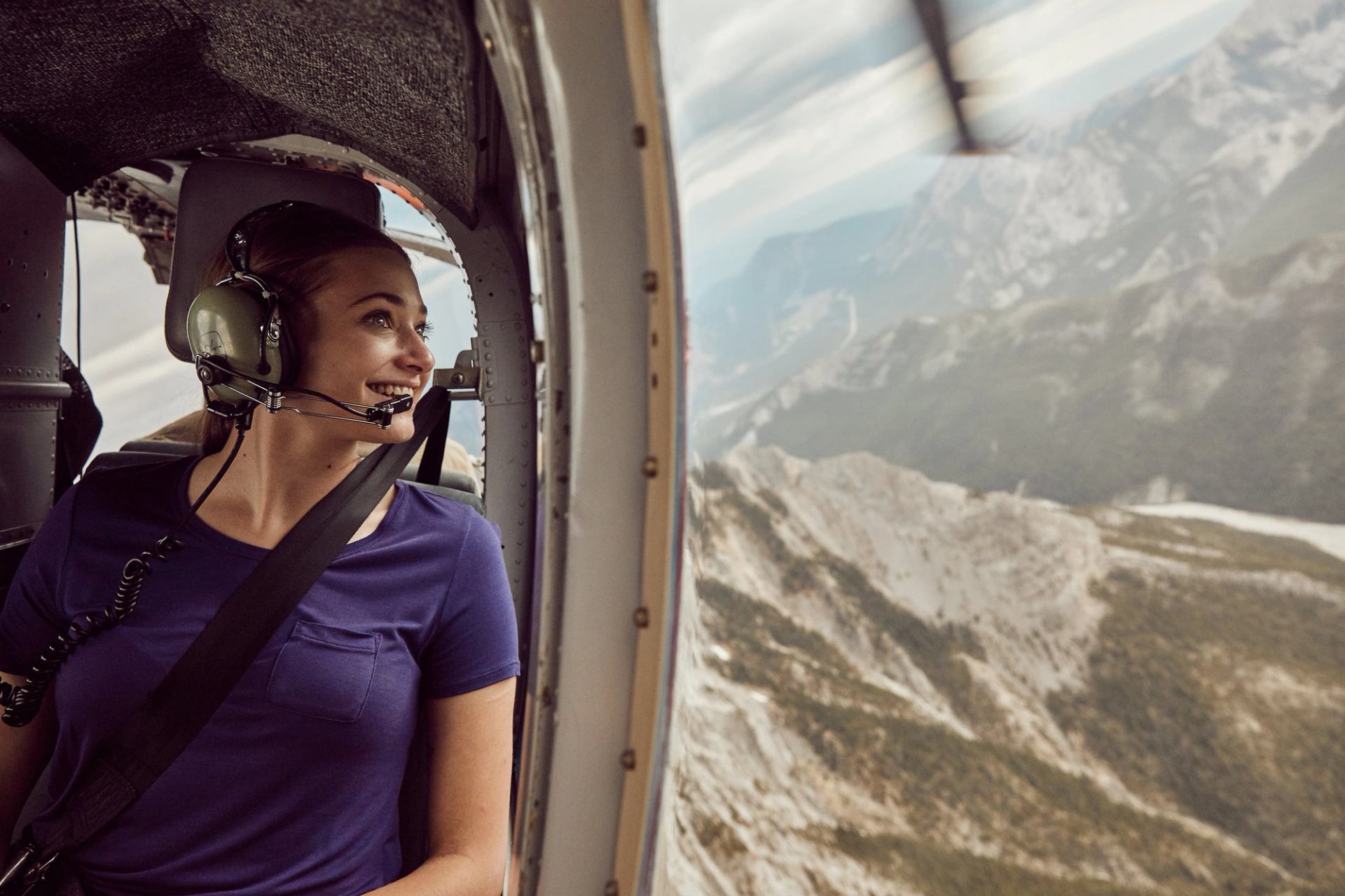 Tourist looking out of the helicopter during her heli tour