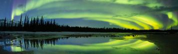 Northern lights stretch across the sky over a lake in Wood Buffalo National Park.
