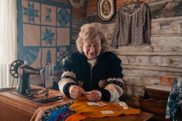 Indigenous women sewing at a desk.