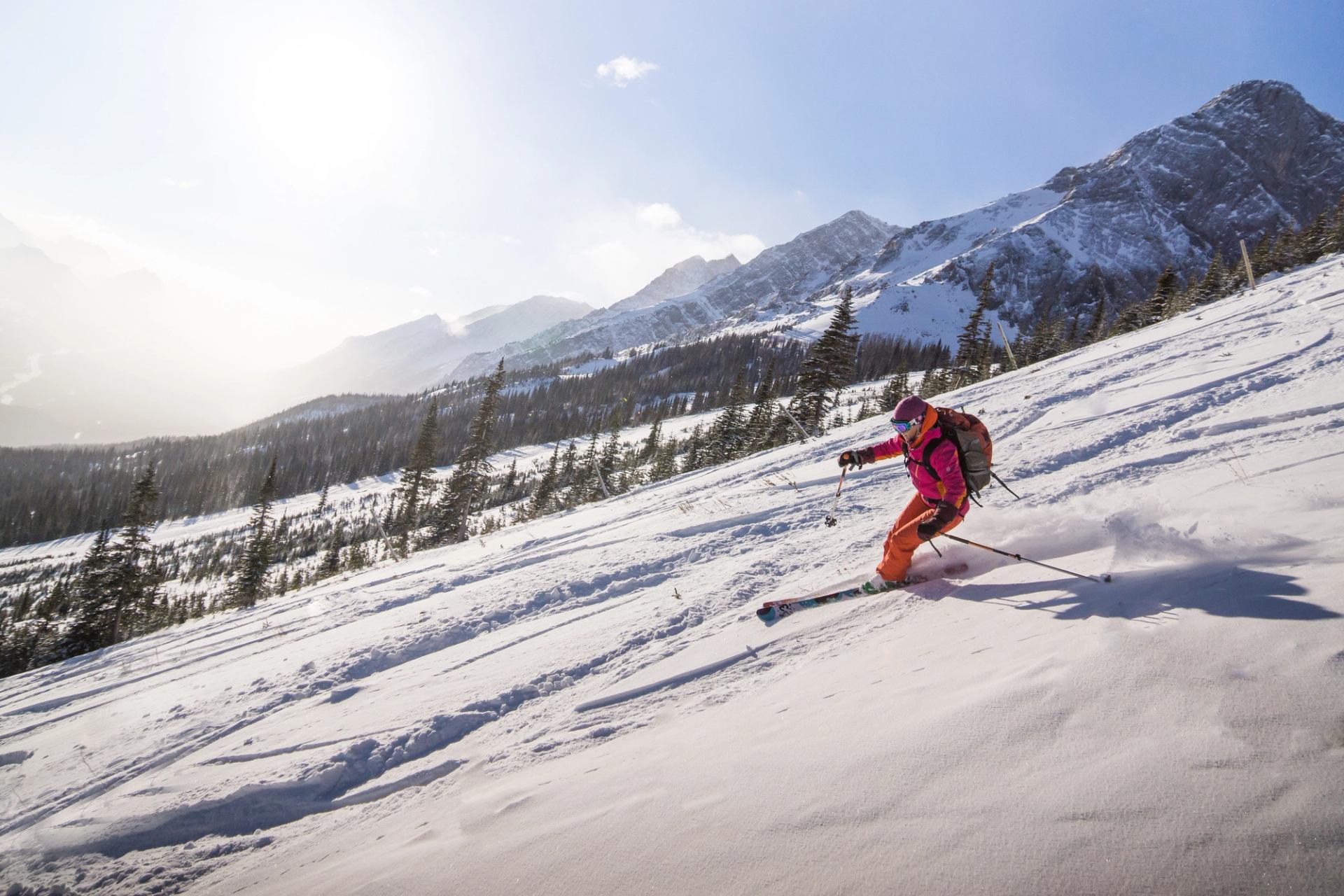 A skier with a backpack, carving and skiing the backcountry at Fortress Mountain in Kananaskis Country in Alberta.