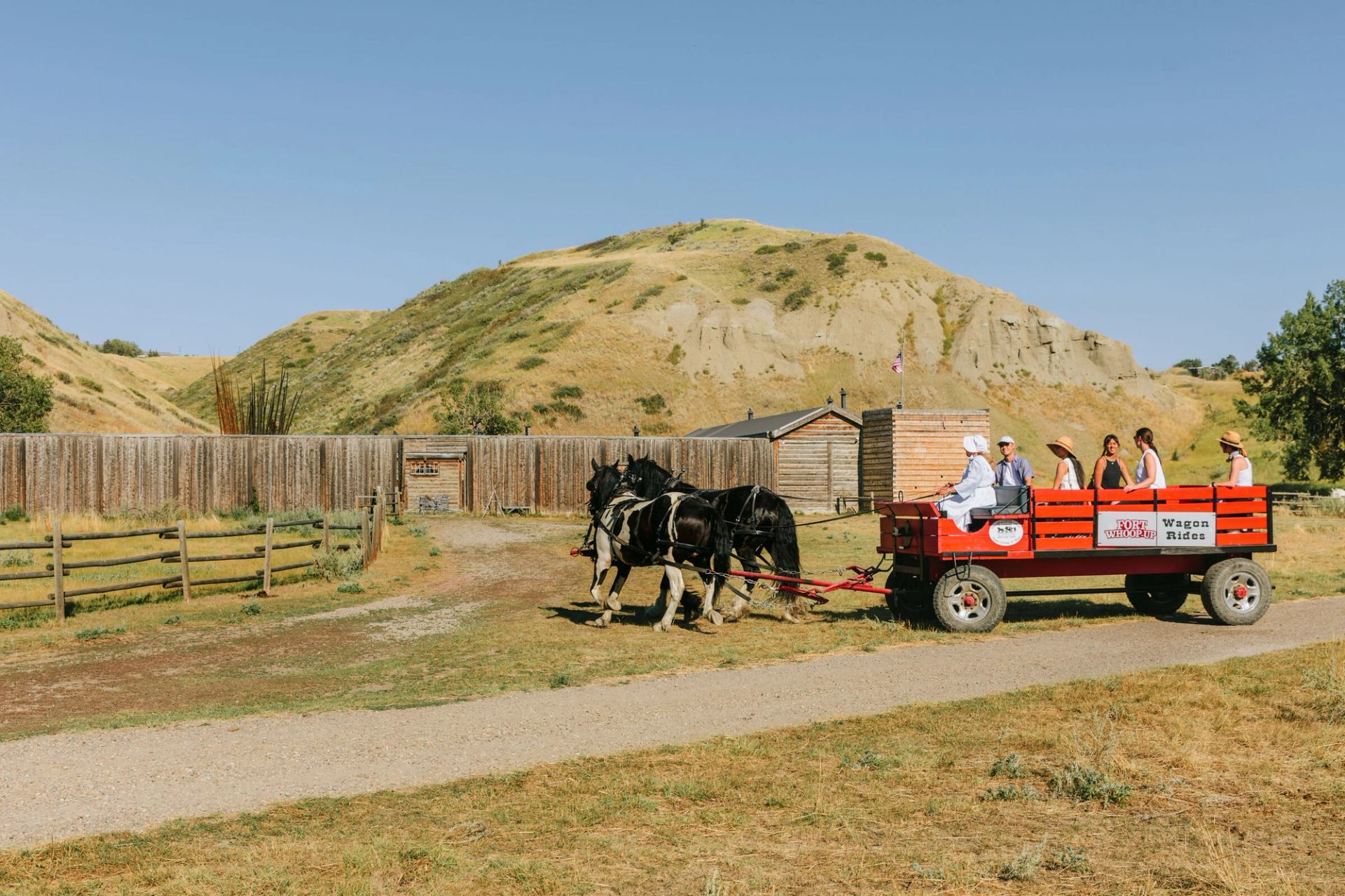 Visitors on a horse-drawn wagon ride at Fort Whoop-Up in Lethbridge.