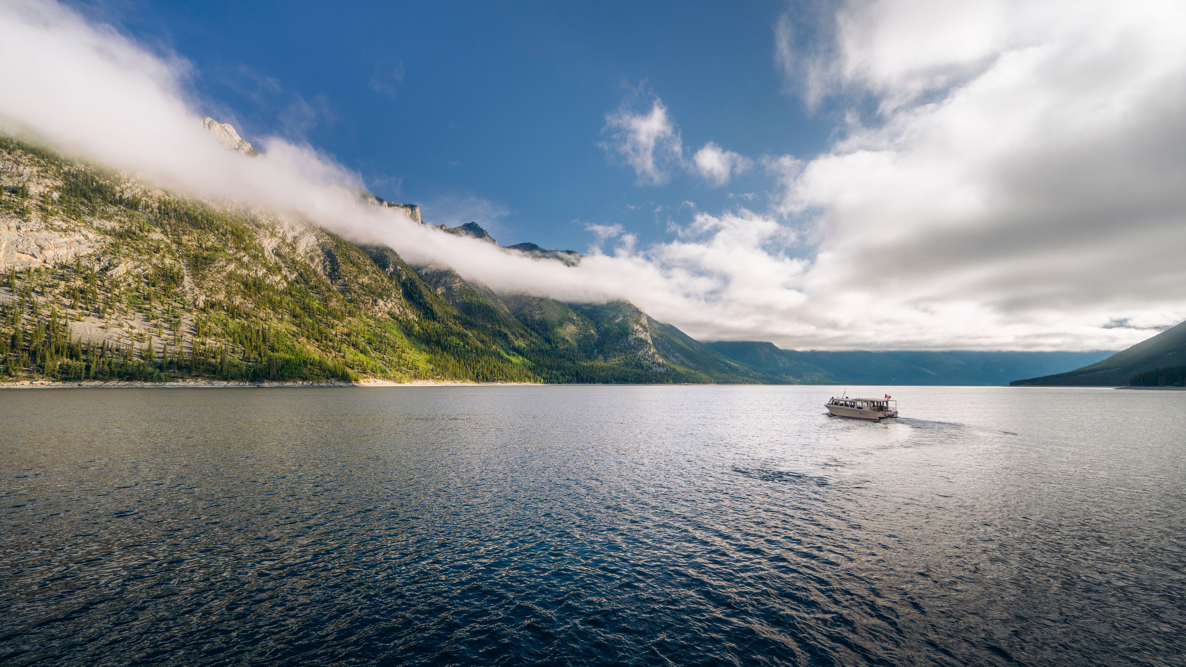 A tour boat crosses Lake Minnewanka.