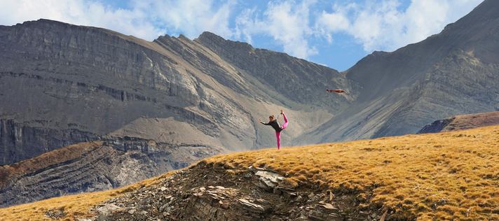 Female doing yoga in front of mountains