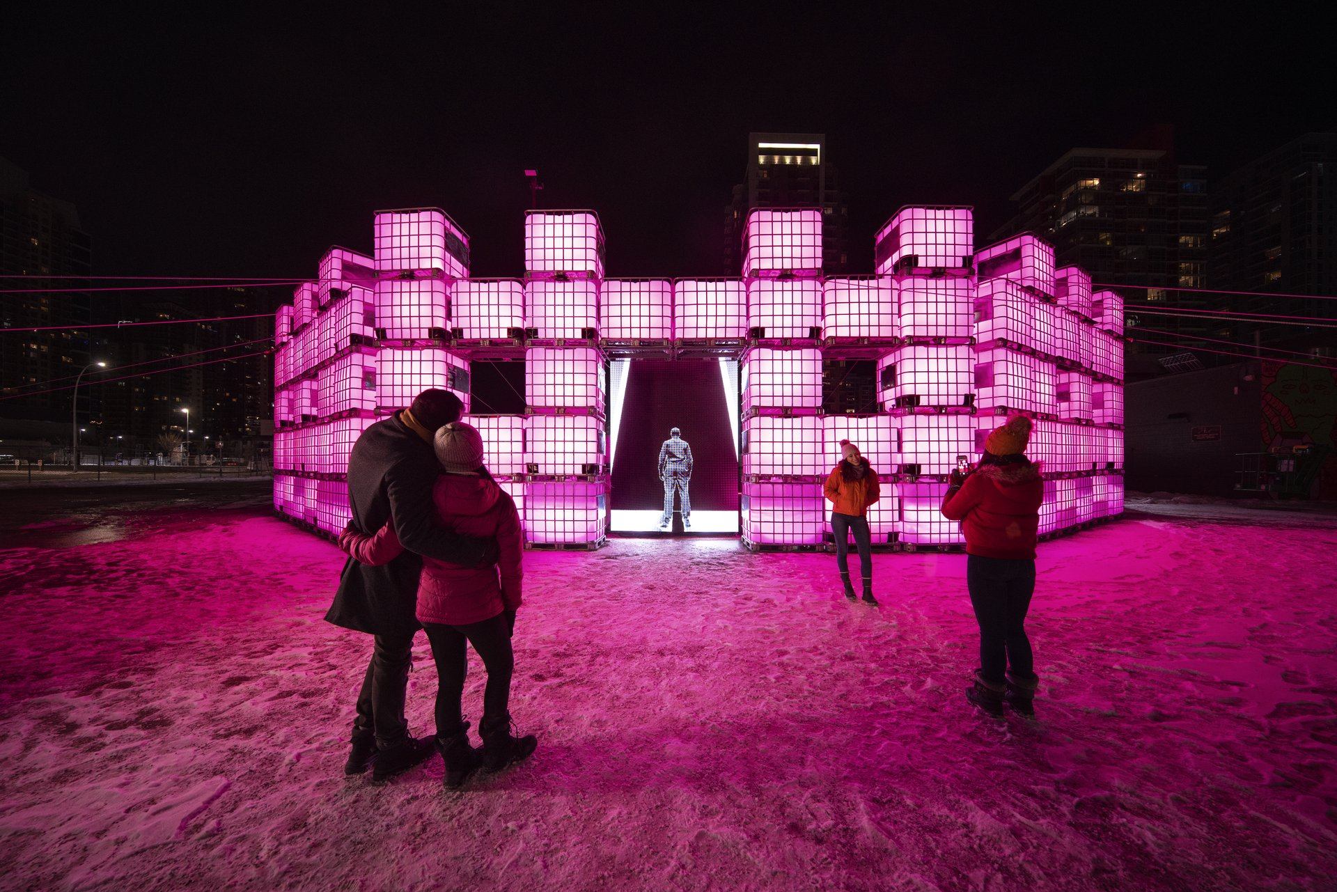 Visitors check out a pink glowing fort-like art installation at Chinook Blast in Calgary.