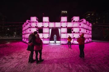Visitors check out a pink glowing fort-like art installation at Chinook Blast in Calgary.