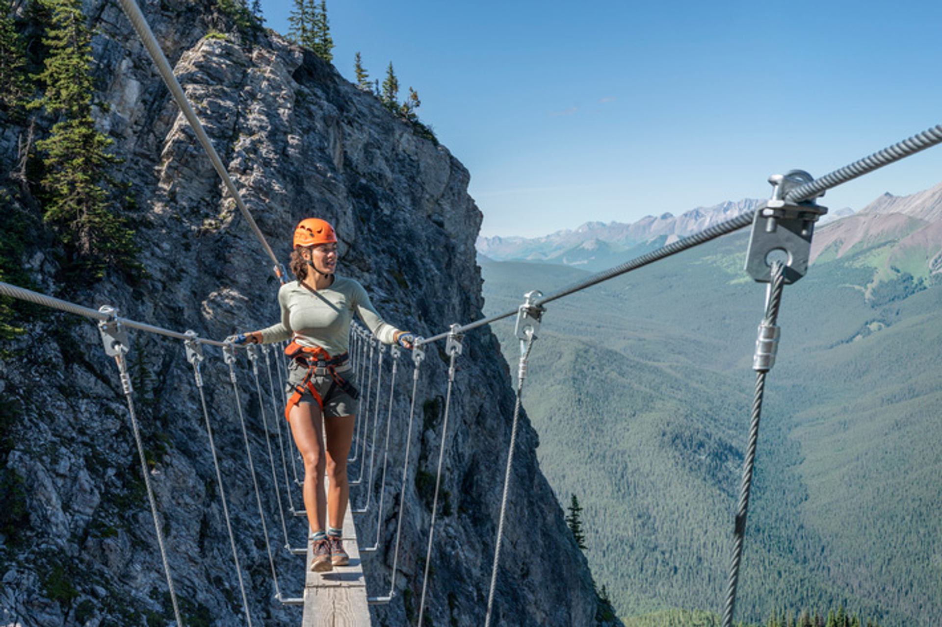 A woman walking on the Via Ferrata suspension bridge at Mt. Norquay.