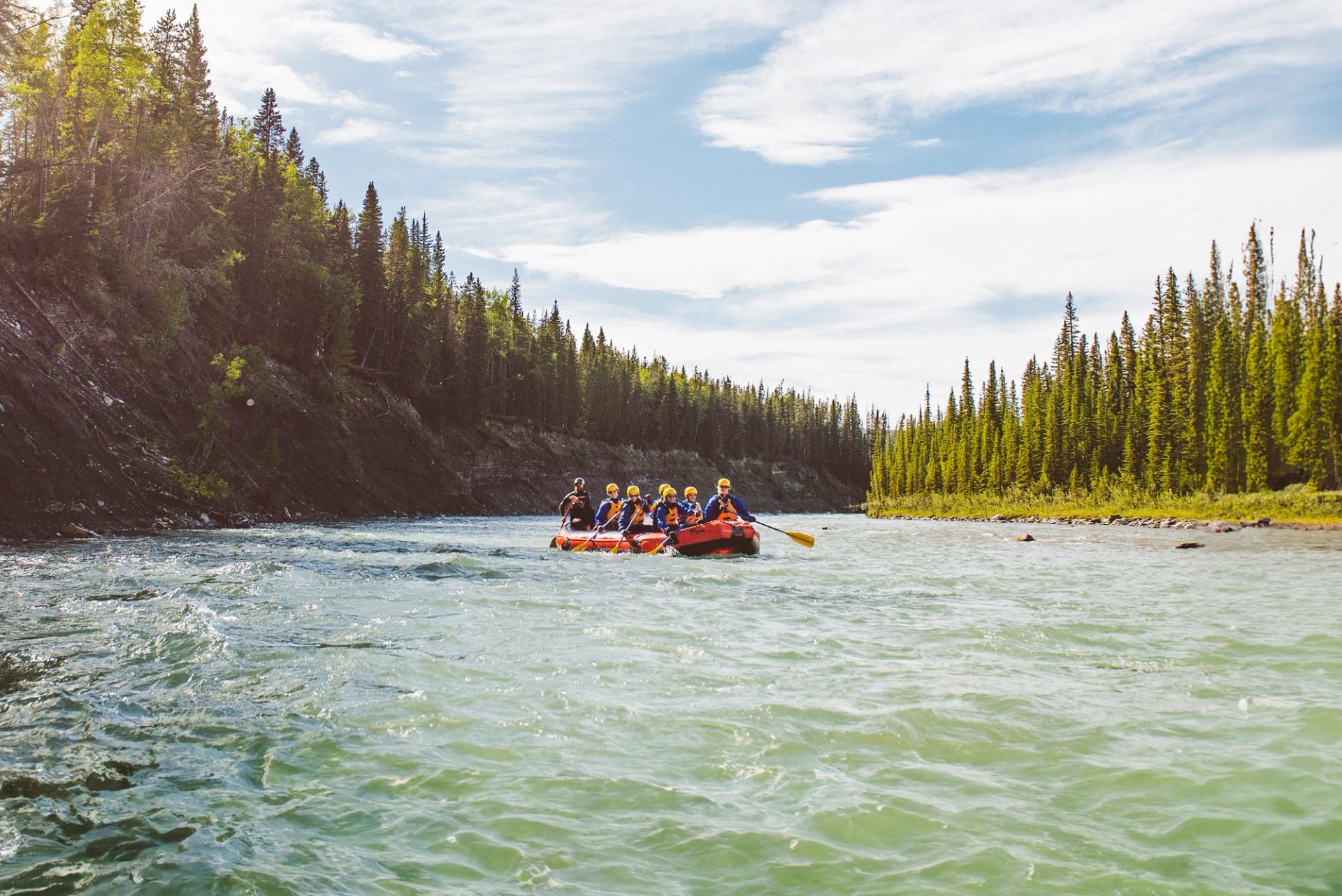 A group of people taking part of the Mukwah Rafting Tour on a raft floating down the Panther River.