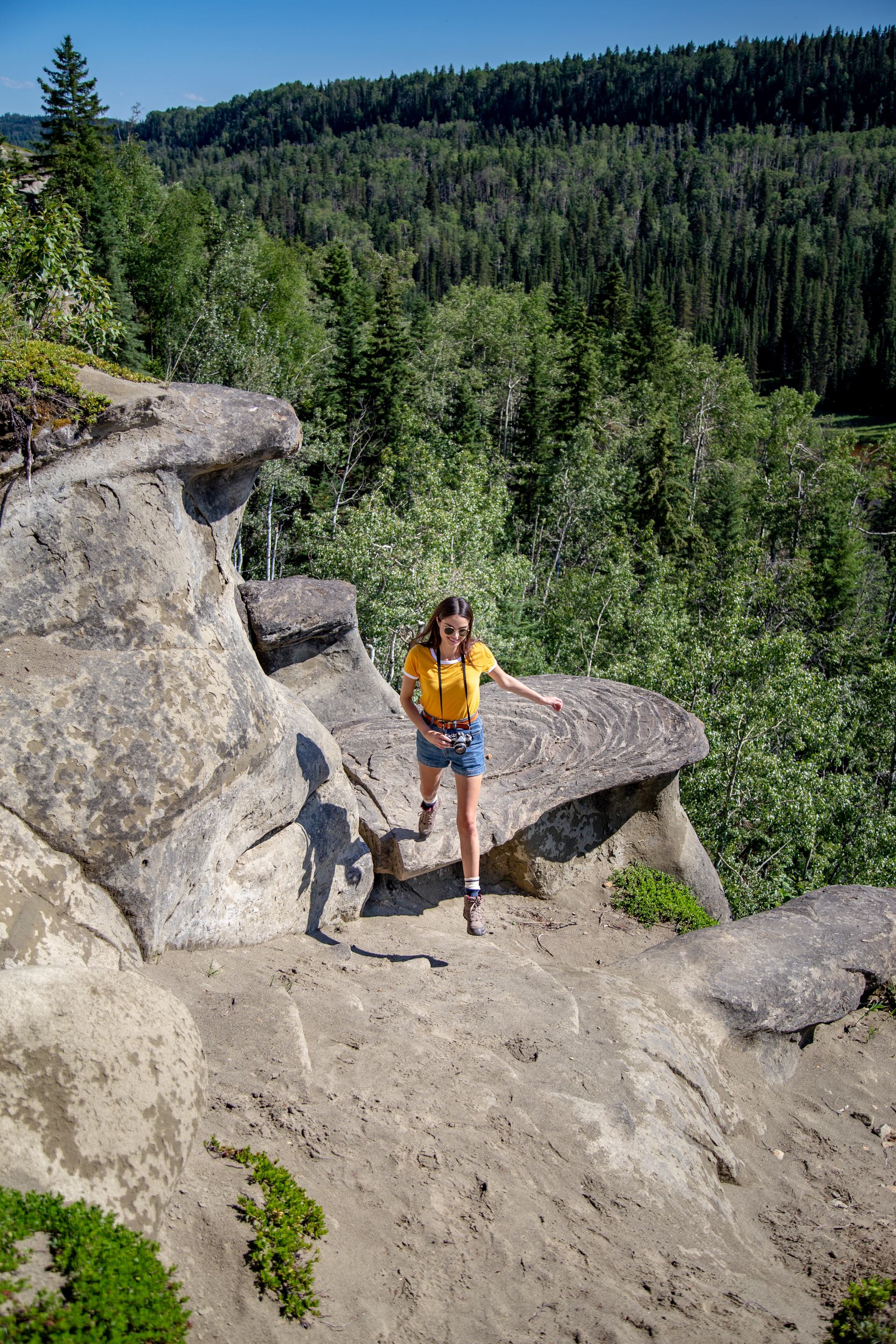 A woman hikes through the hoodoos at Sundance Provincial Park.