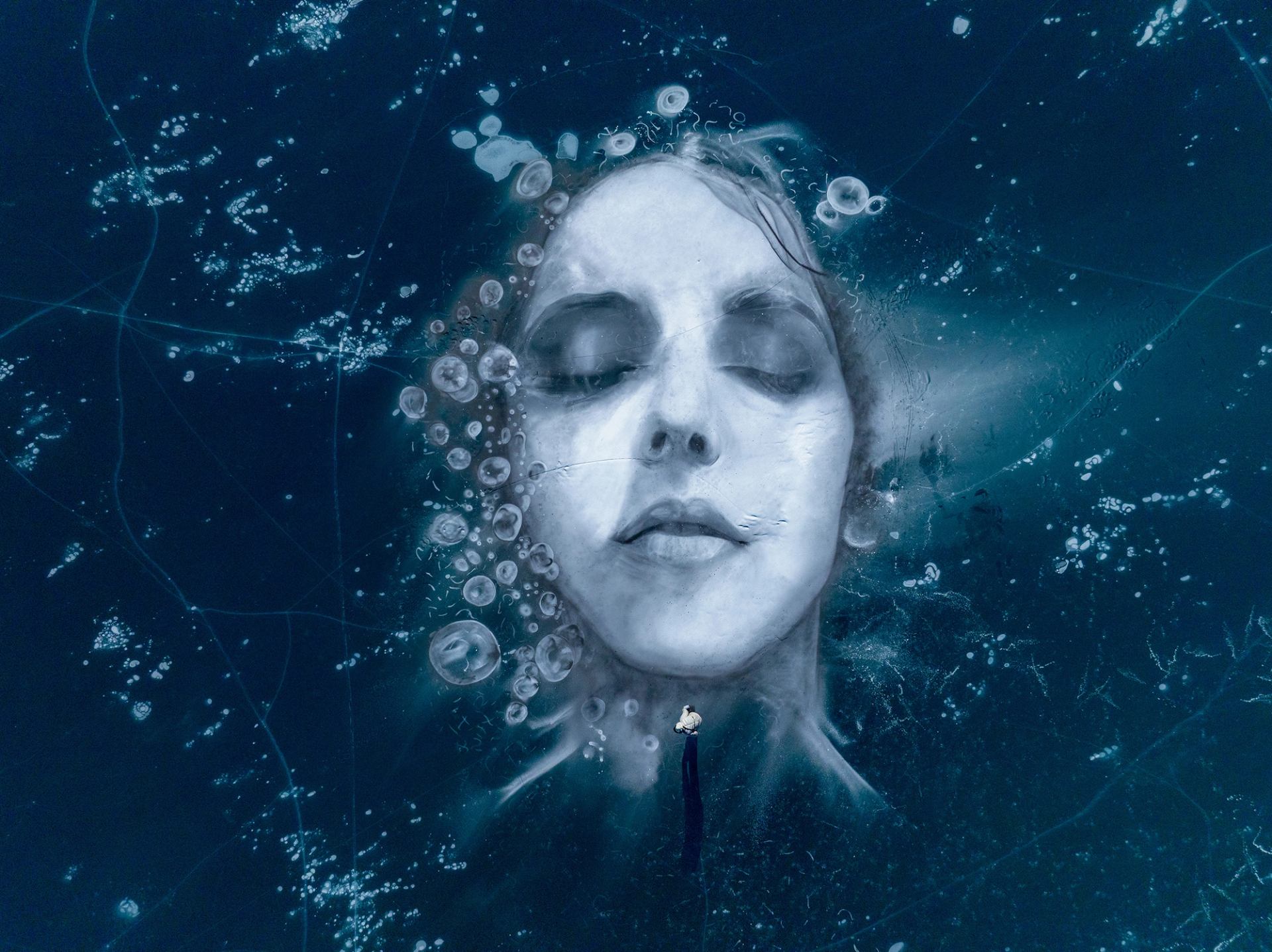 Artist David Popa stands near the chin of his 80-foot portrait on Abraham Lake’s frozen surface.