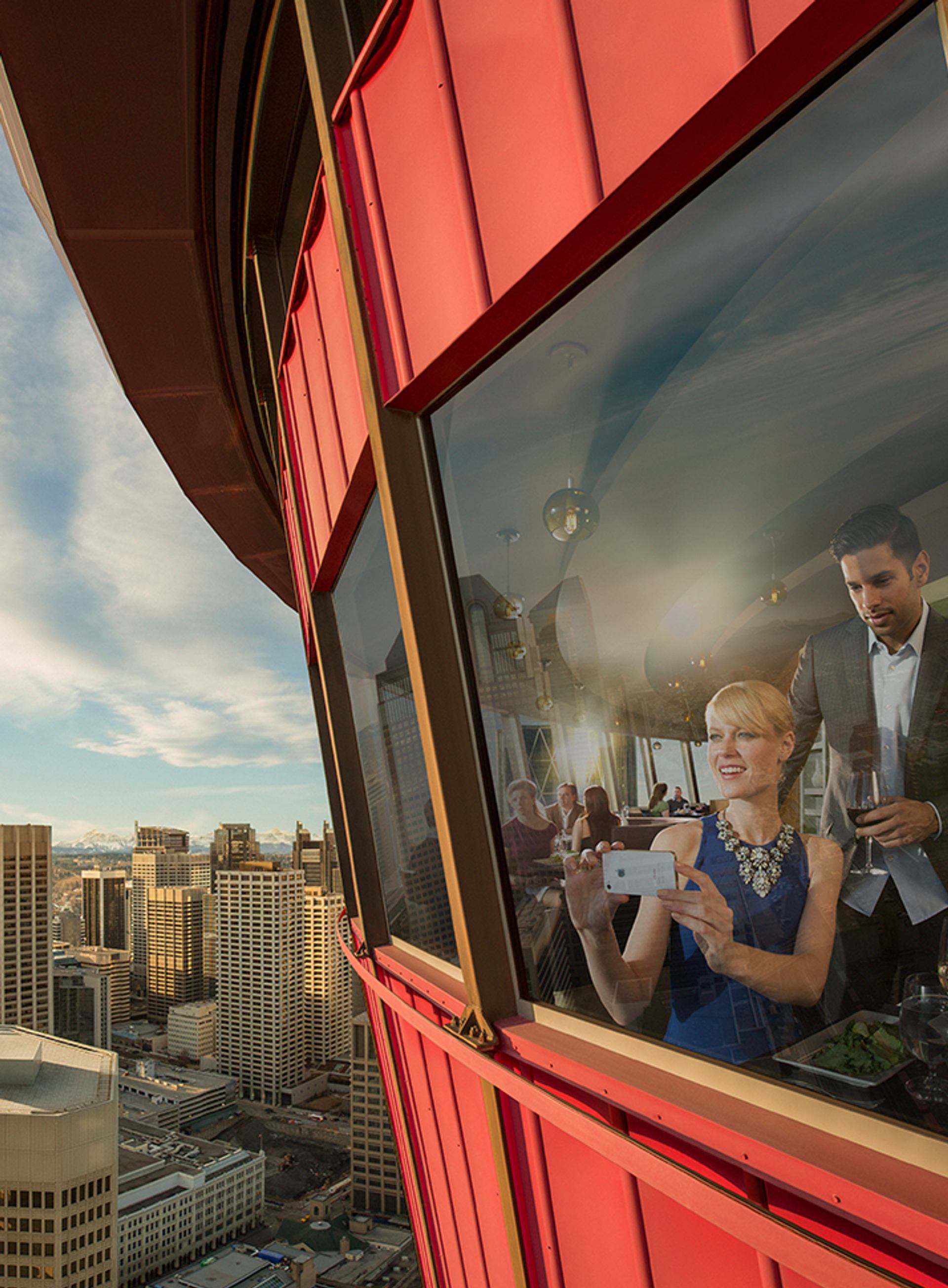 Couple having dinner at Sky 360 restaurant with views of the city skyline from the Calgary Tower.