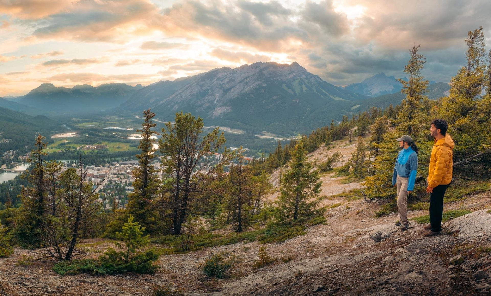 A pano shot of two hikers overlooking the view of Banff from Tunnel Mountian.