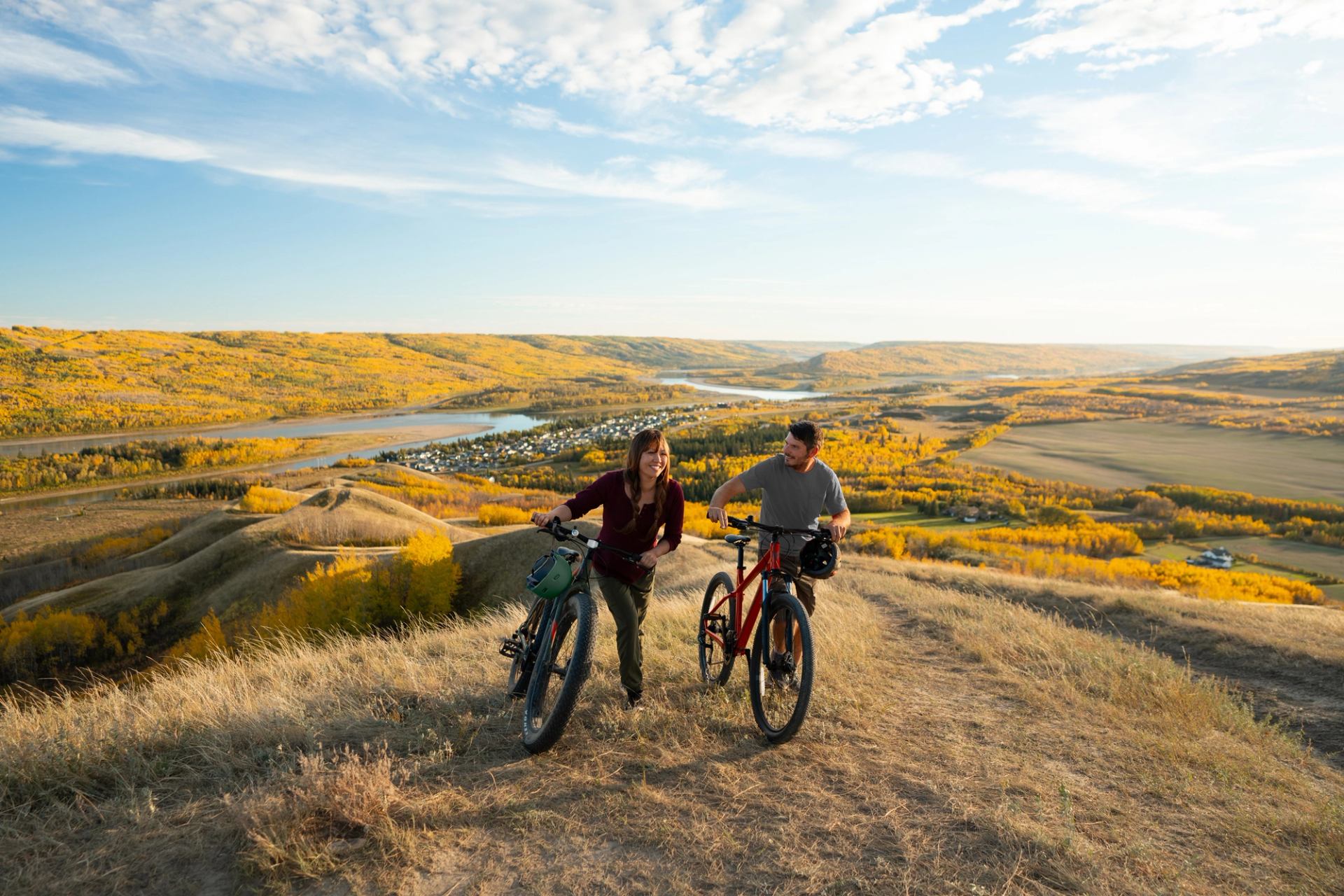 Mountain bikers head back up Misery Mountain in Peace River, with fall colours all around them.