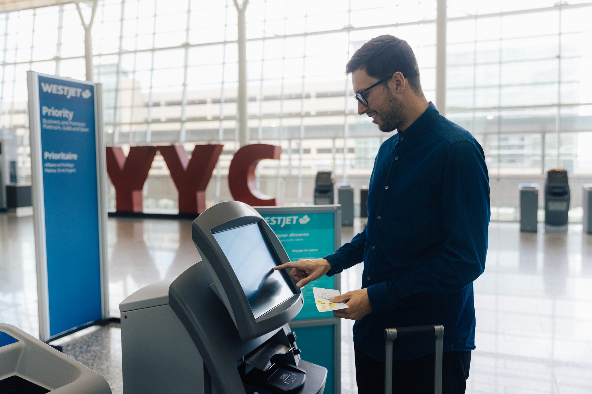 Man checking in at airport kiosk.