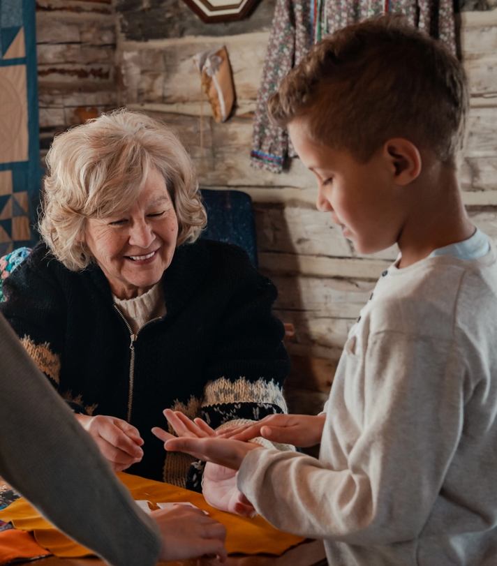 An Indigenous woman showing children how to sew and make crafts at Métis Crossing in Smoky Lake.