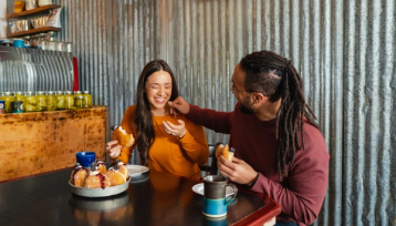 Man and woman enjoying hot beverages and pastries at The Westwood in Diamond Valley