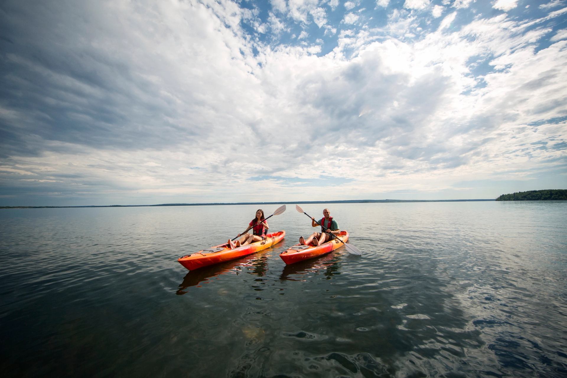 couple tap oars as they kayak on Lac la Biche in sir winston churchill provincial park