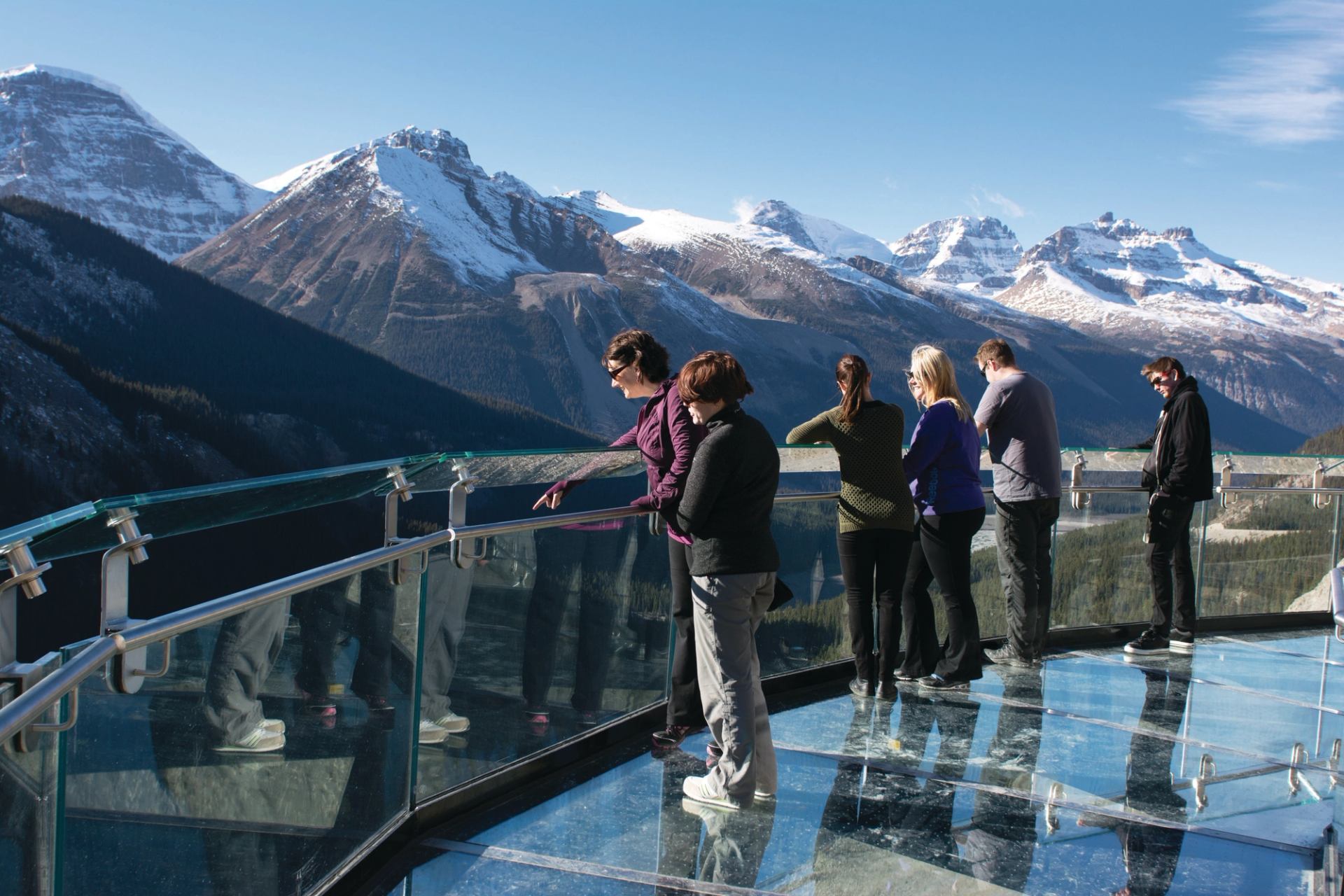 Visitors standing on the glass-floor platform of the Glacier Skywalk hovering 280 metres (919 feet) above the Sunwapta Valley