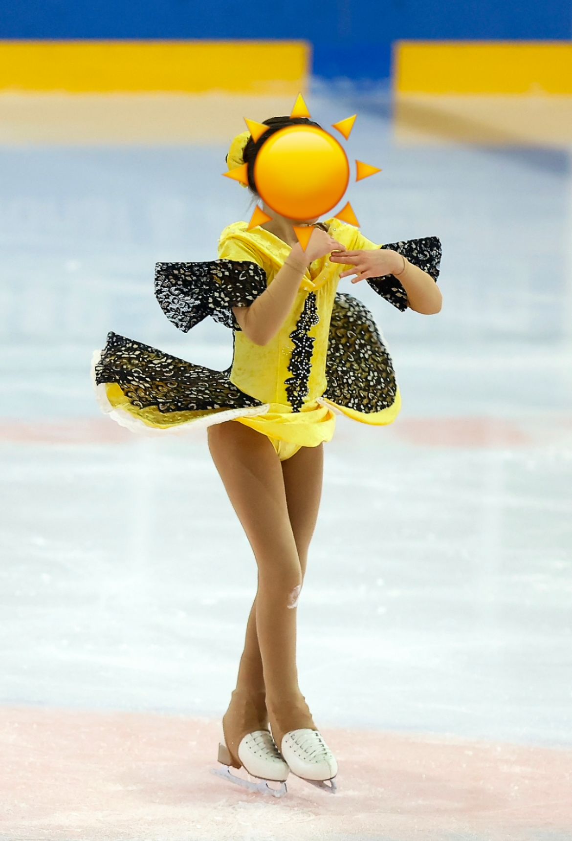 Eiskunstläuferin im gelb-schwarzen Sonnenkleid