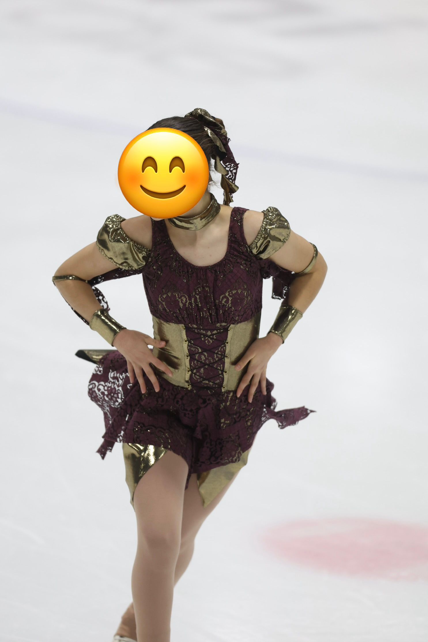 Eiskunstläuferin im bordeauxroten Kleid mit goldener Korsage