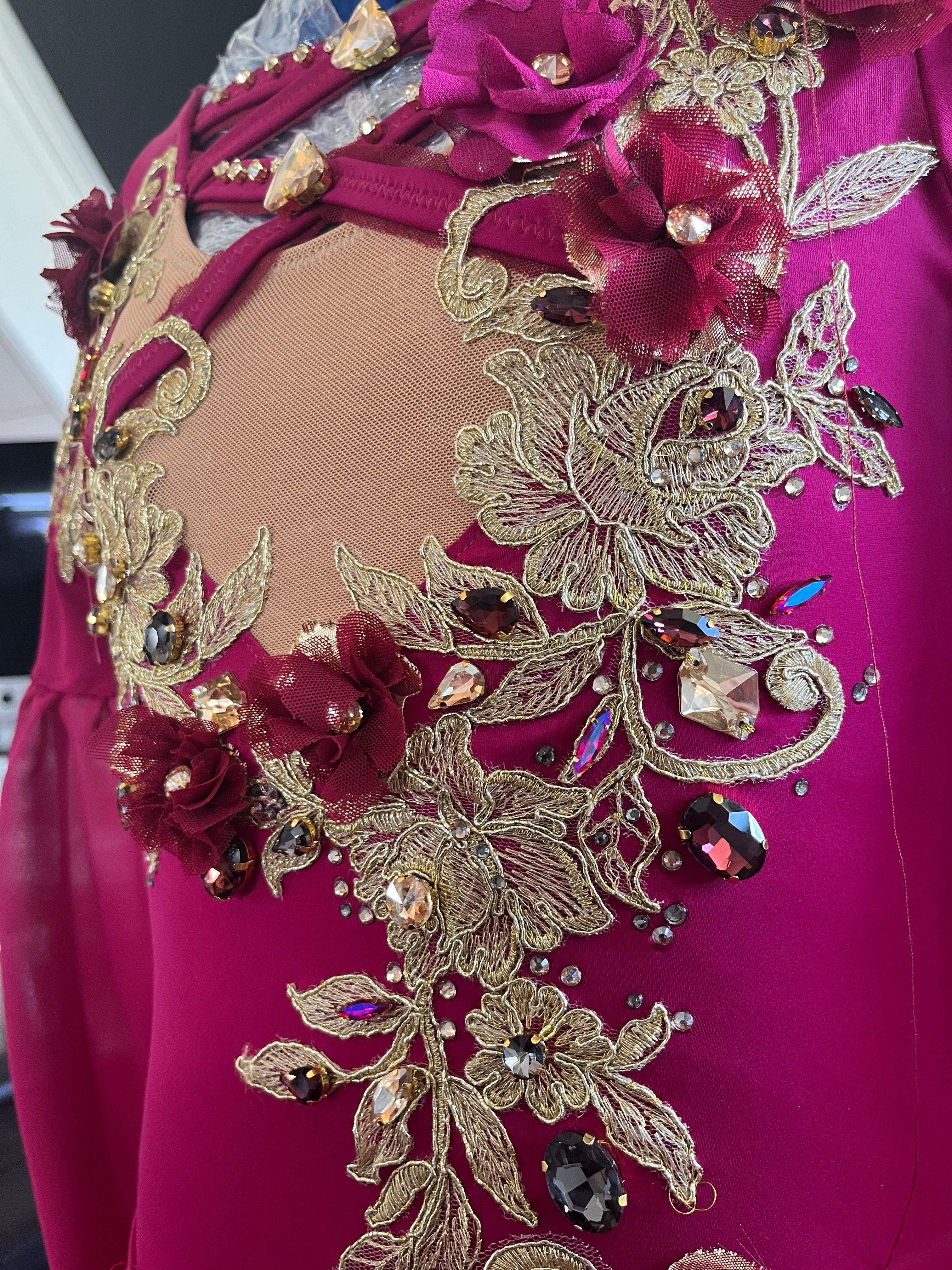 Detail: Blumenstickerei mit Steinen auf pinkem Stoff
