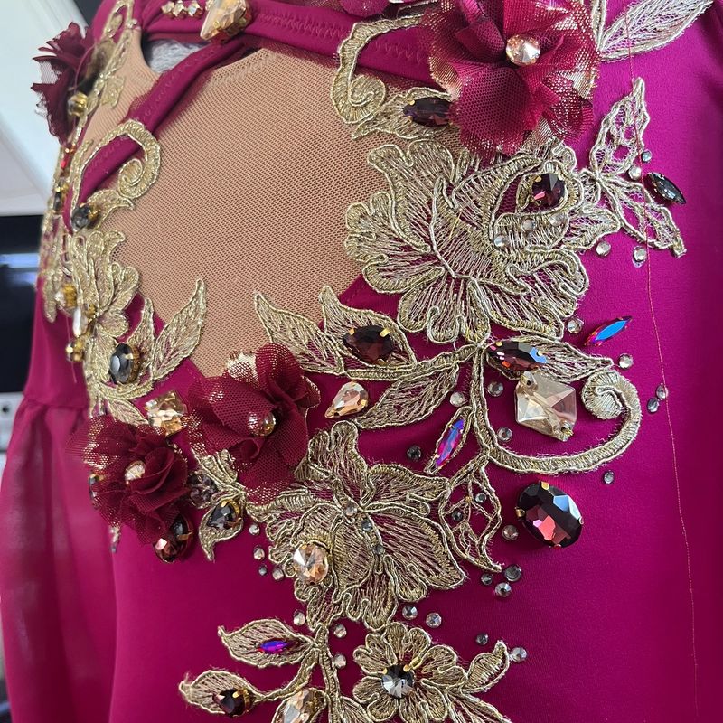 Detail: Blumenstickerei mit Steinen auf pinkem Stoff