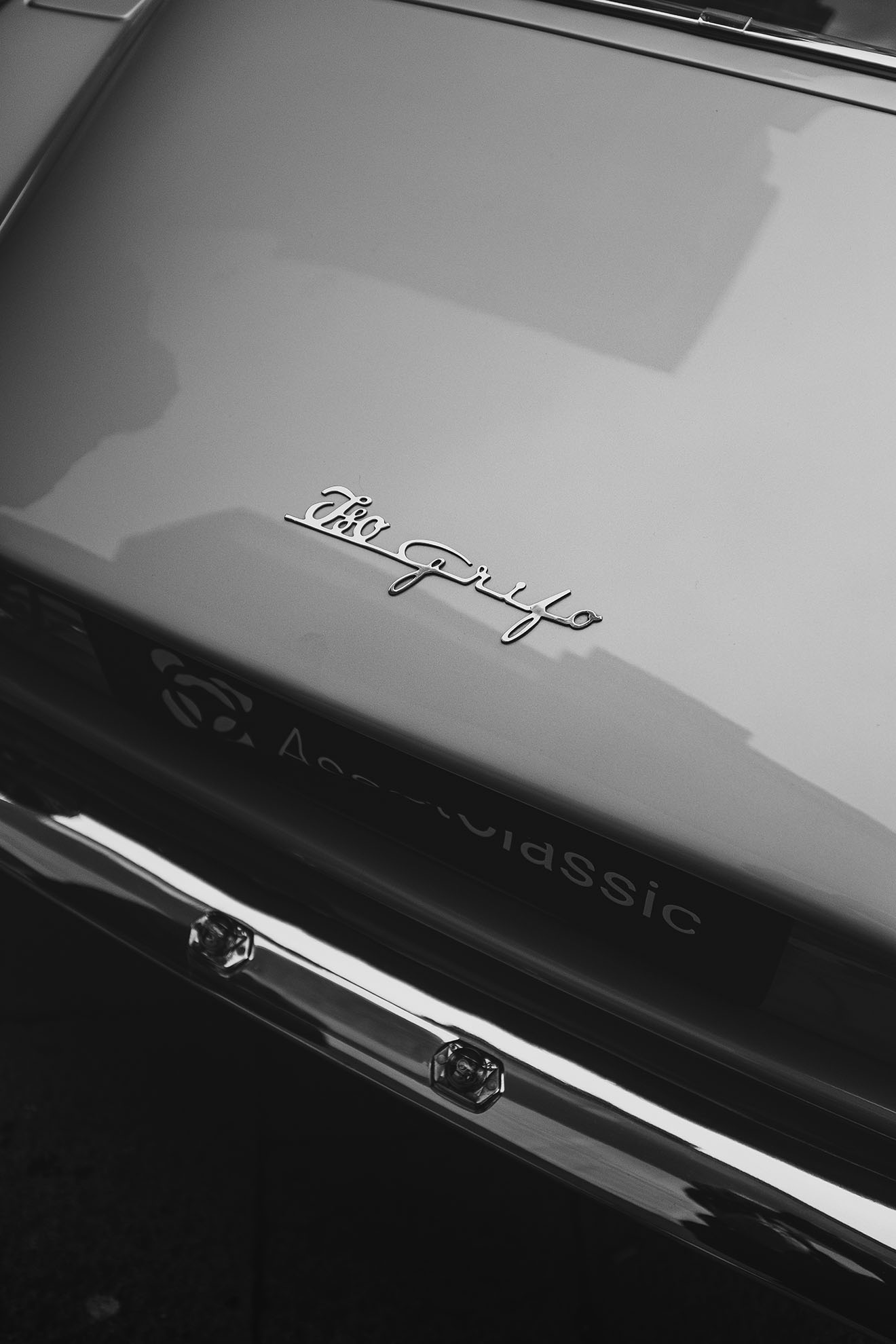 Dettaglio in bianco e nero della scritta “Aero Griffa” sul cofano posteriore di un’auto classica.