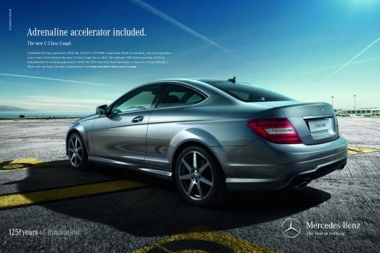Silver Mercedes-Benz C-Class Coupé parked on a sunny day, showcasing its sleek design with the slogan 'More style per hour. The new C-Class Coupé. 125 years of innovation. The best or nothing.' emphasizing luxury and heritage.