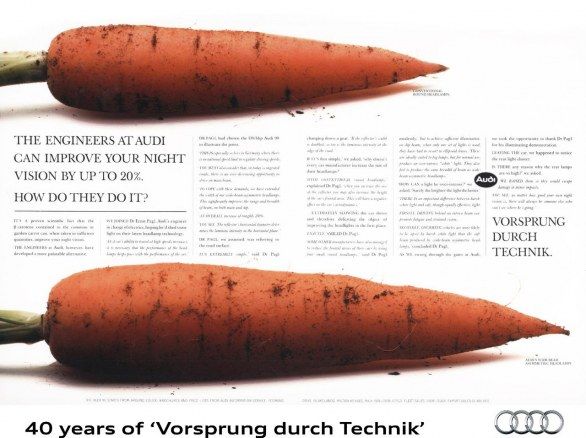 Advertisement featuring two large carrots against a white background with text claiming Audi engineers can improve your night vision by up to 20%, celebrating '40 years of Vorsprung durch Technik'. The Audi logo and slogan are prominently displayed, linking the qualities of carrots with Audi's innovative automotive technology.