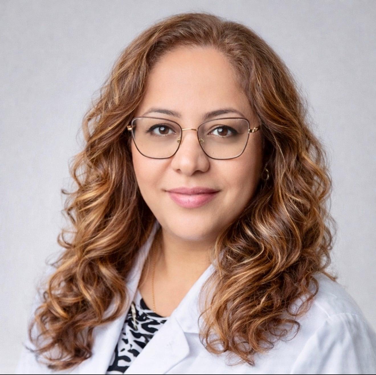 Dr. Akram Nikpour, DDS, in a white coat