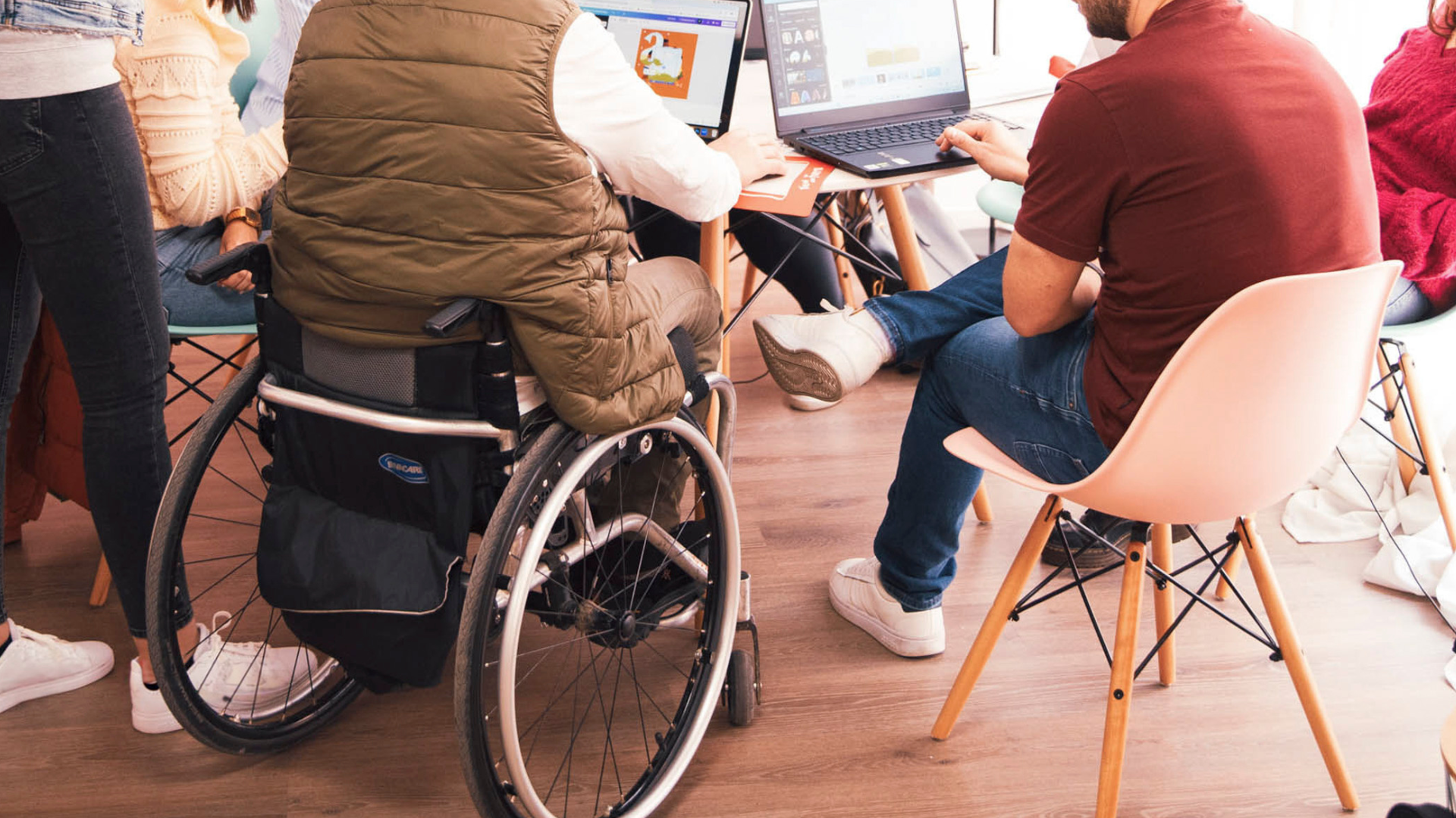 Jong iemand in een rolstoel achter een computer