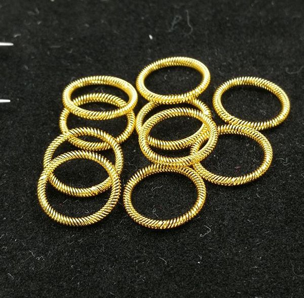 Cluster of circular gold-plated canted coil spring contact rings on black surface