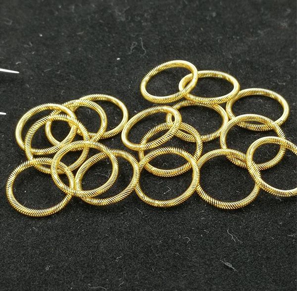 Gold-plated circular canted coil spring contact rings on a dark background