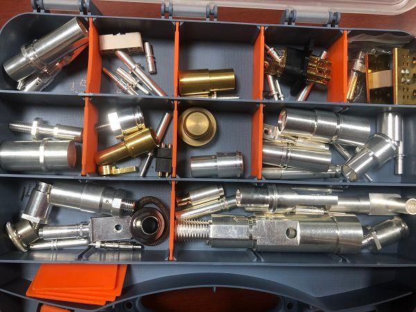 Assorted silver and gold plated precision machined connector pins, sockets, and terminals in organizer