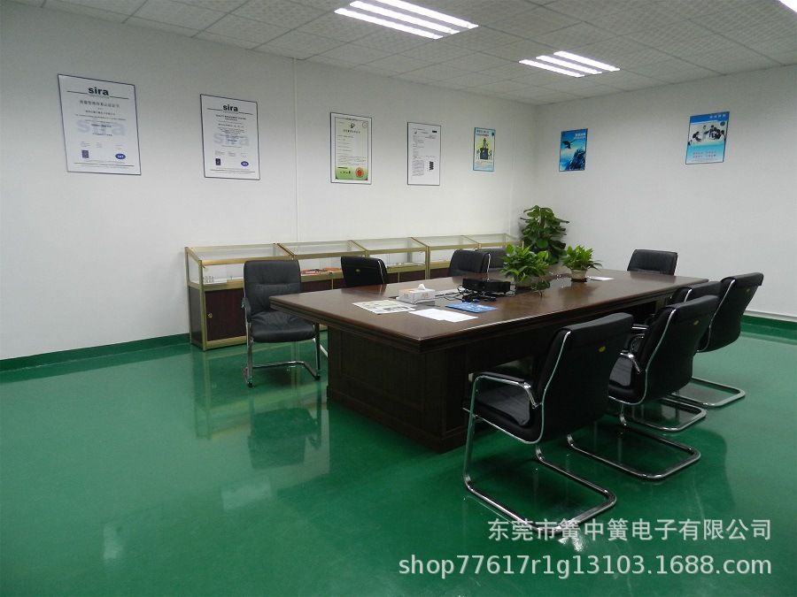 Factory conference room with wooden meeting table, chairs, and ISO certification certificates on the wall