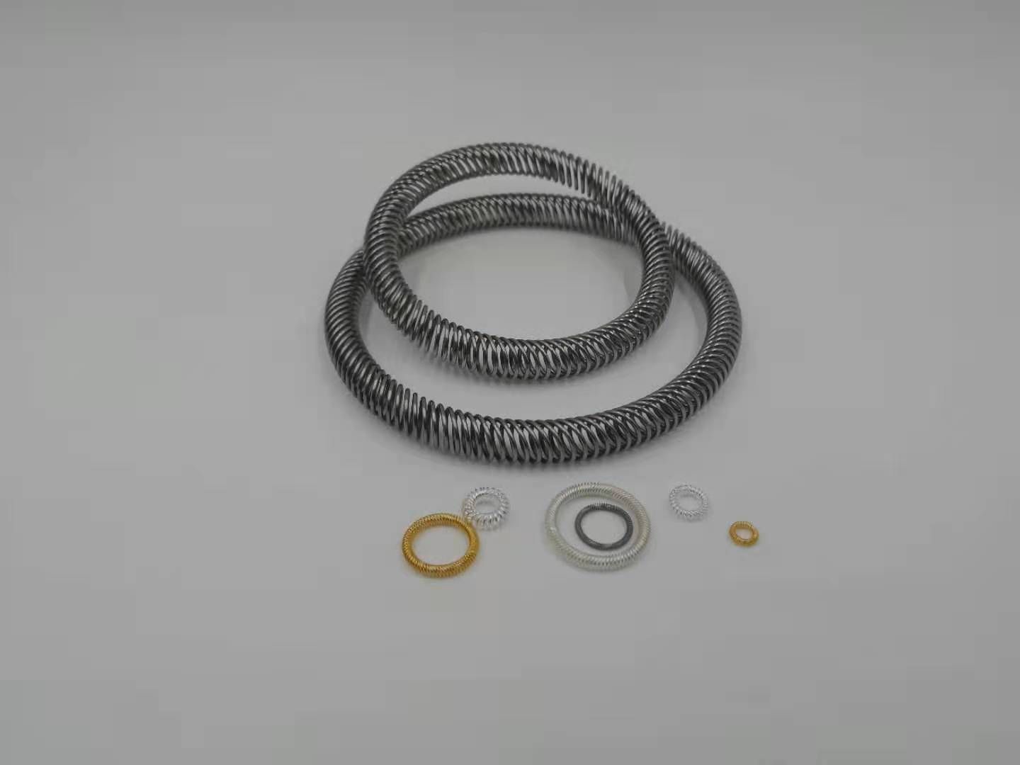 Assorted canted coil spring rings in large and small diameters with gold and silver plating