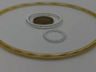 Gold-plated and silver-plated canted coil spring rings shown with a comparison coin