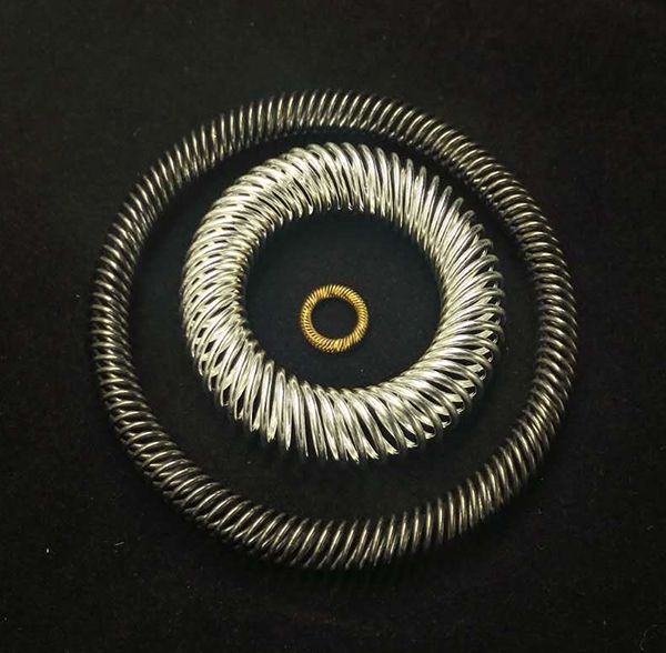 Concentric canted coil spring rings with silver and gold plating on black background