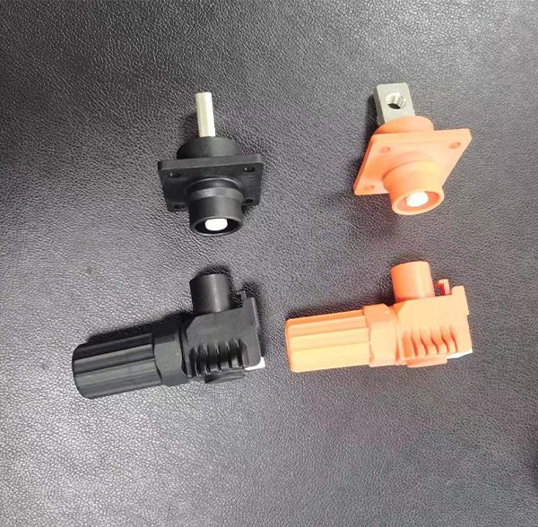 High-voltage EV connector plugs and panel-mount sockets in orange and black plastic housings