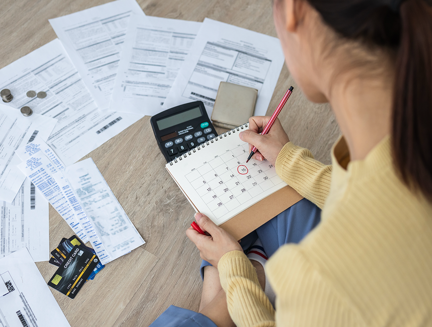 woman sat with her bills and a calculator 