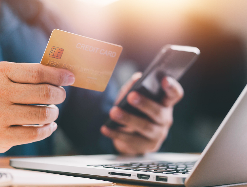 someone holding credit card in one hand and a phone in the other