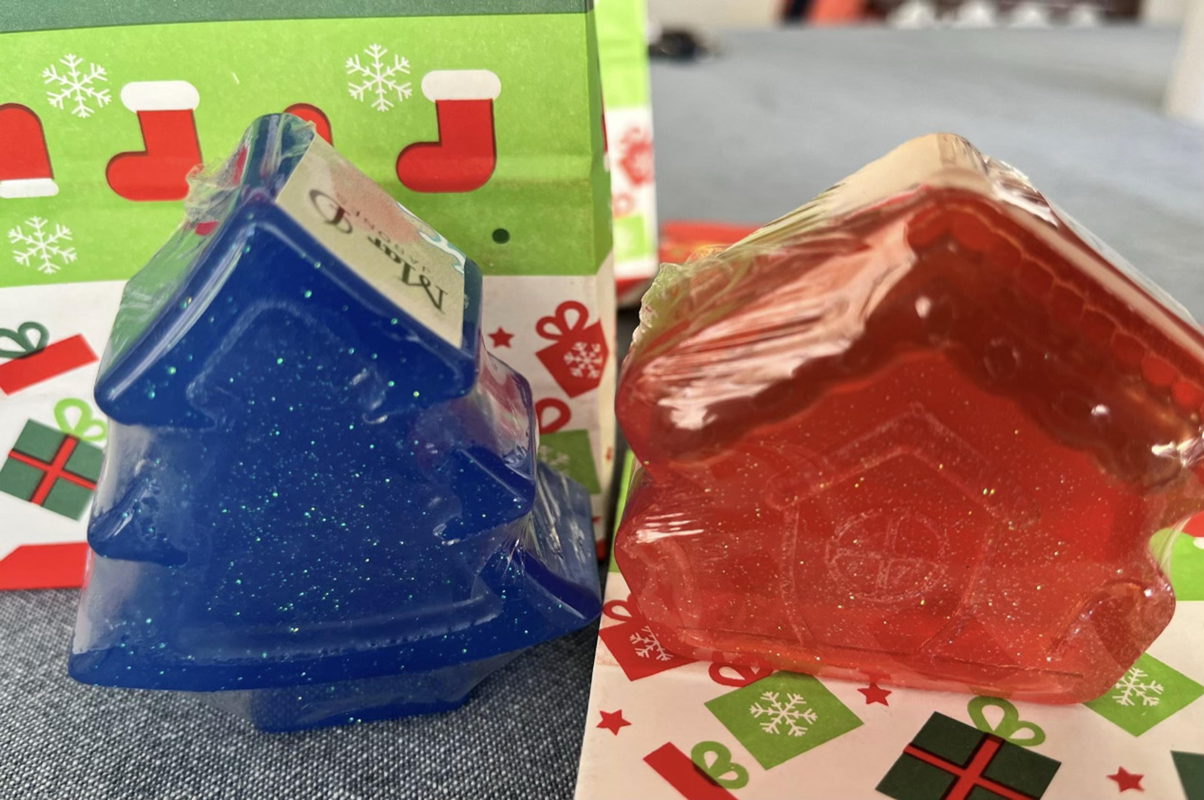 Árbol azul y casita roja de jabón sobre papel navideño