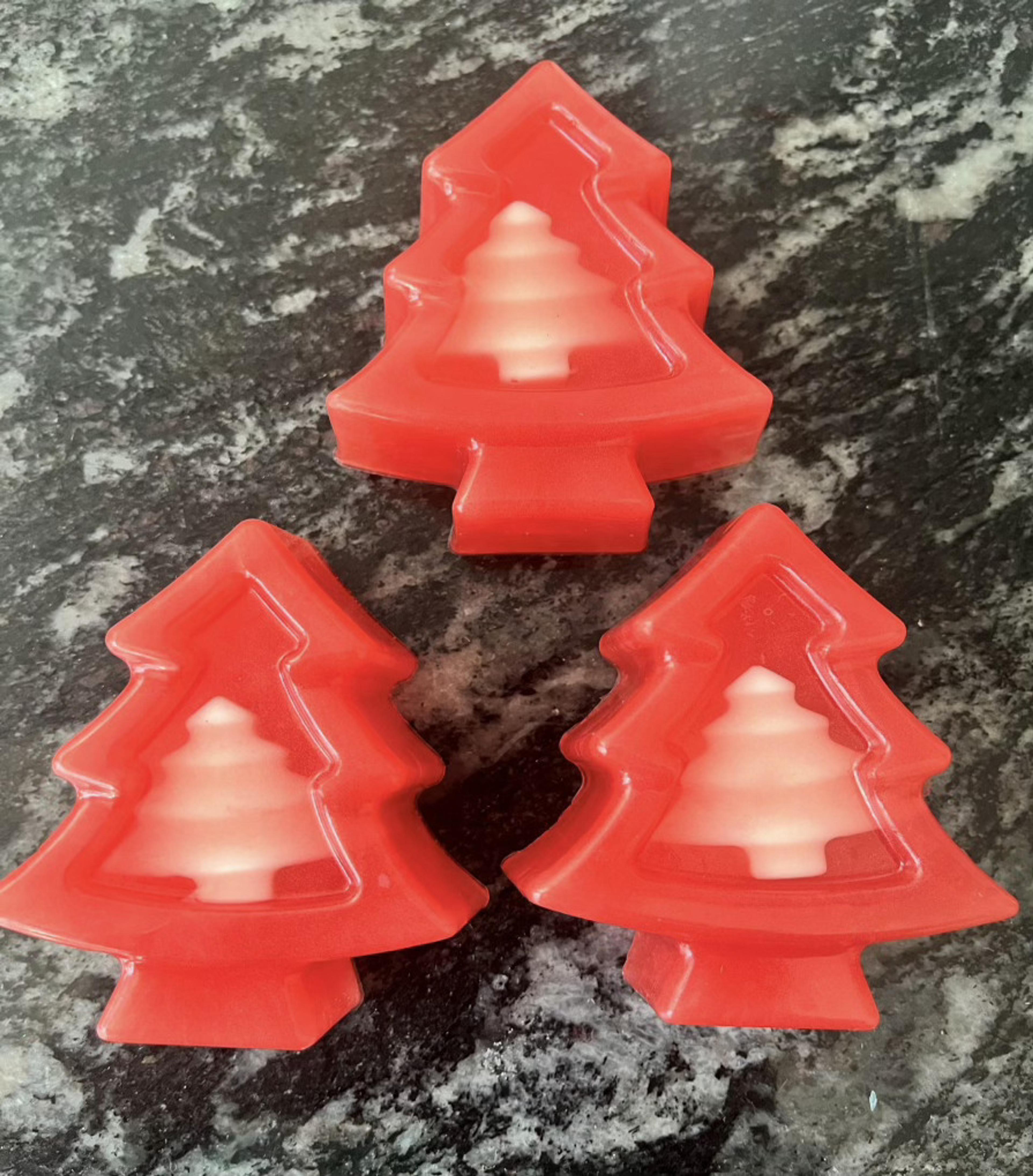 Tres árboles de Navidad rojos con centro blanco