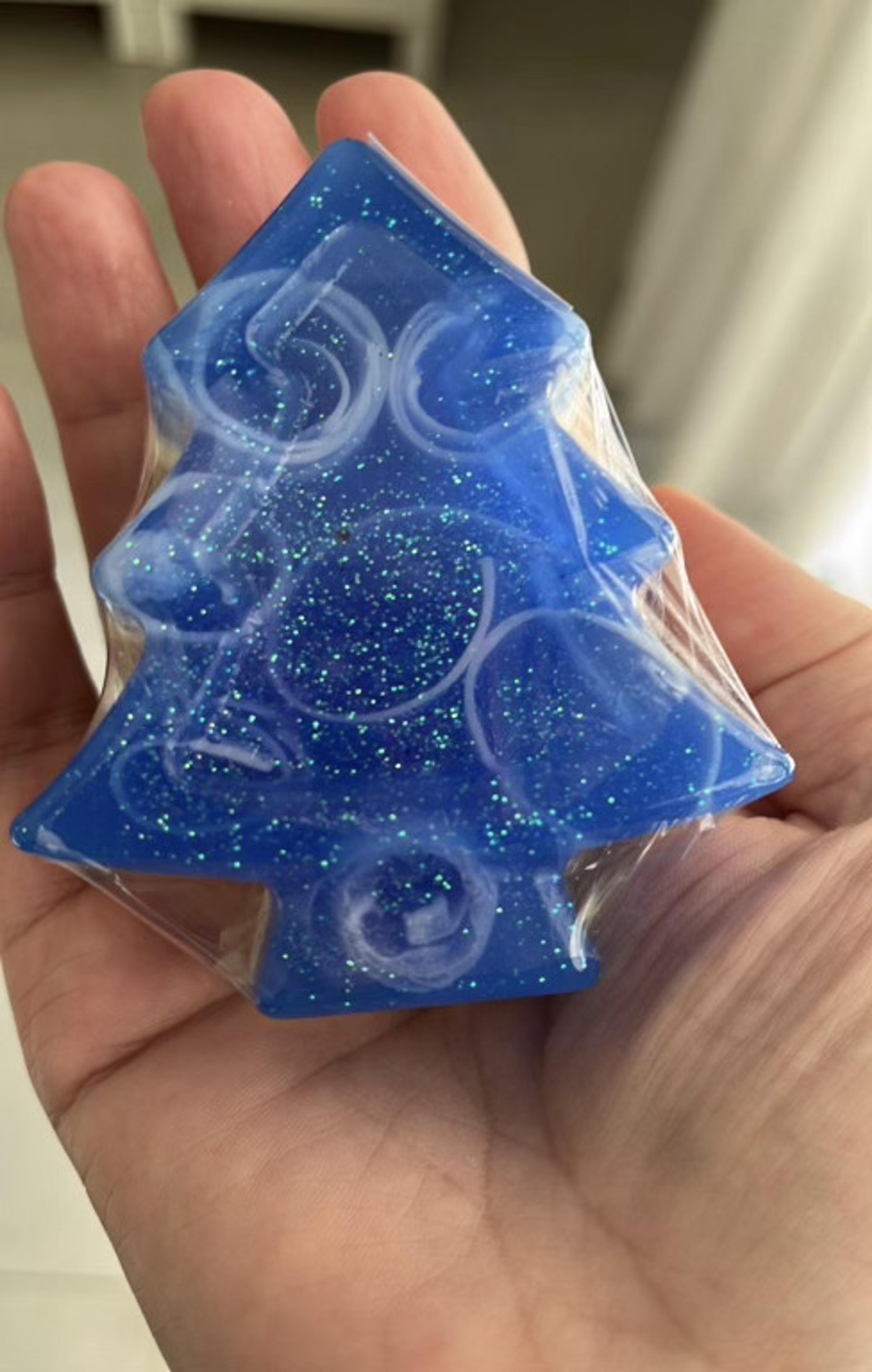 Árbol de Navidad de jabón azul con brillos, en la mano