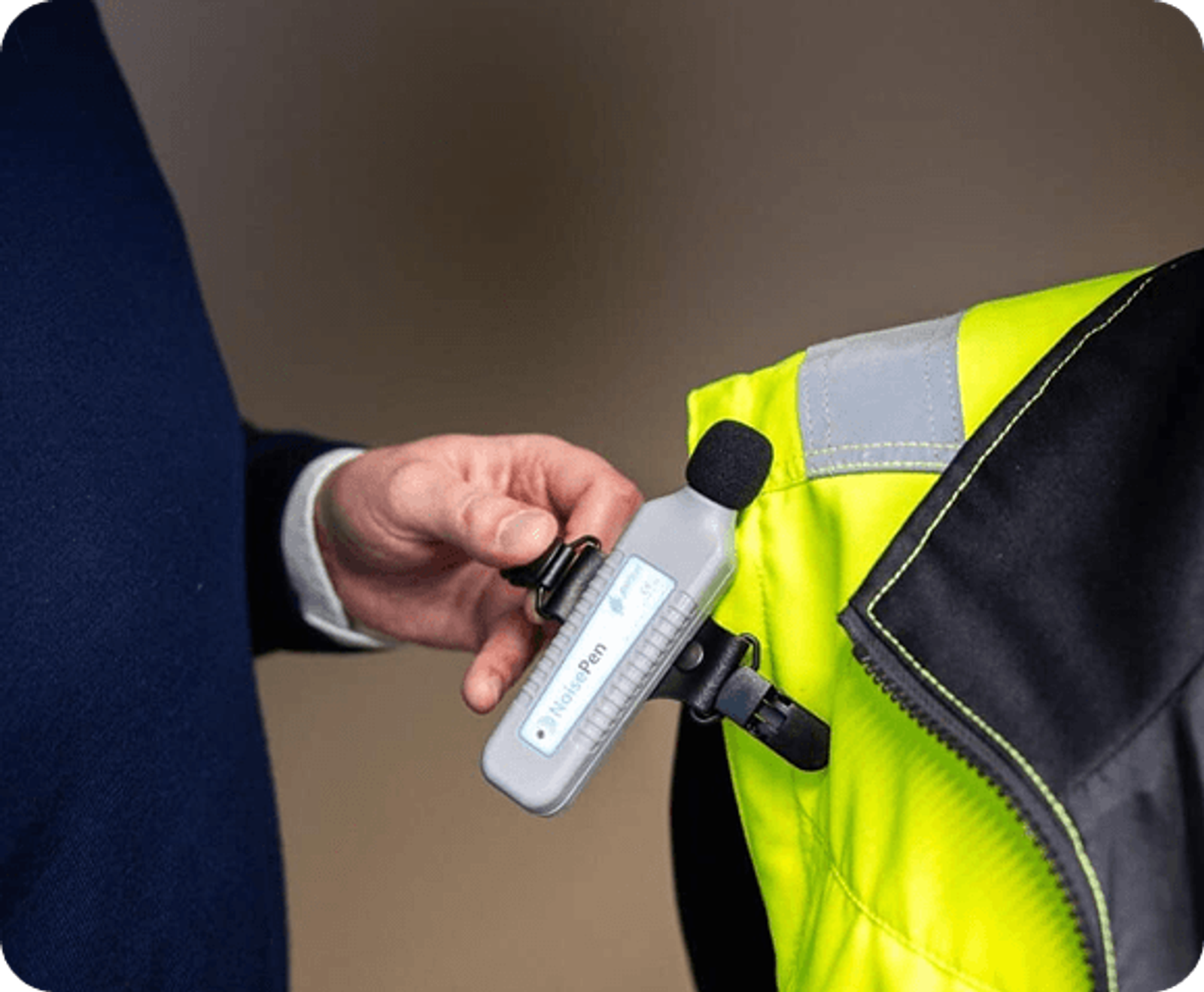 Workplace noise measurement: a NoisePen meter is clipped to a worker’s jacket